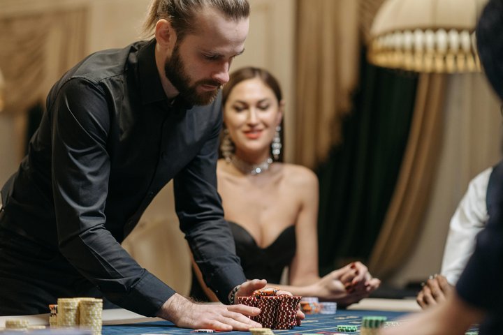 Man sitting at poker table with stacks of chips and cards.